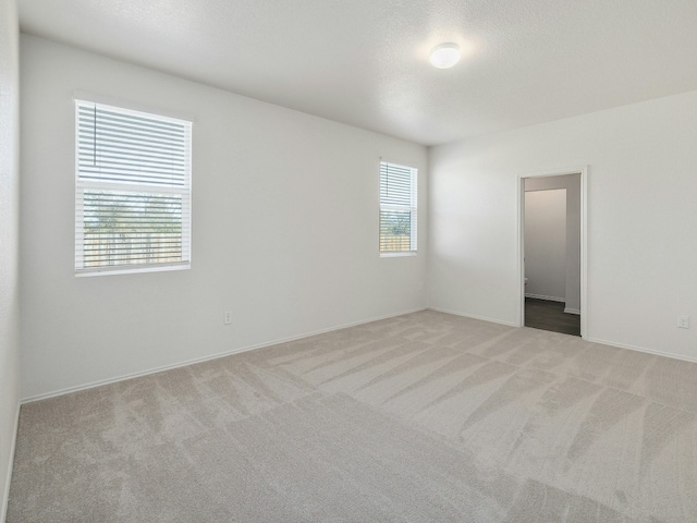 carpeted spare room featuring a textured ceiling