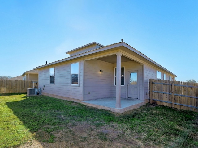 rear view of house featuring central AC unit, a patio, and a lawn