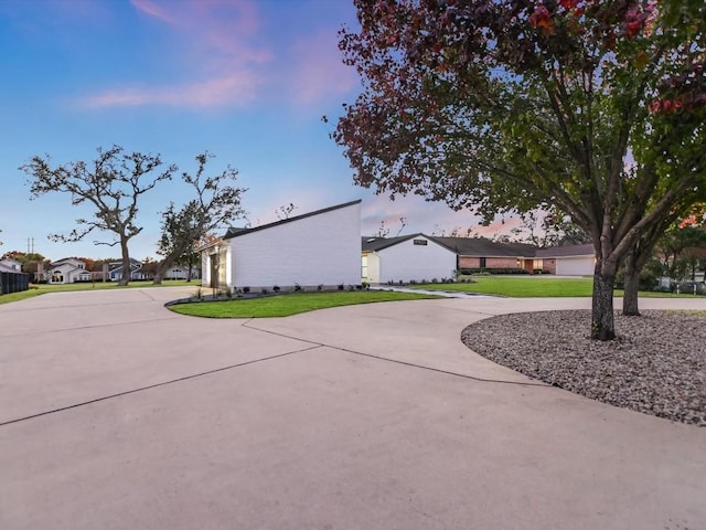 property exterior at dusk featuring a yard