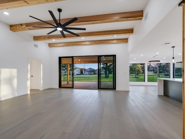 unfurnished living room featuring ceiling fan, beamed ceiling, and hardwood / wood-style flooring