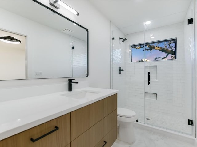 bathroom featuring vanity, toilet, and walk in shower