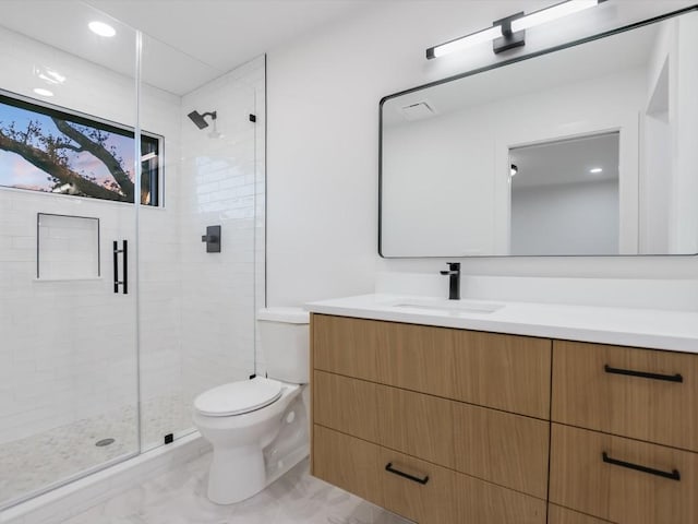 bathroom with vanity, a shower with shower door, and toilet