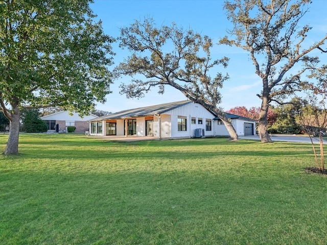 back of property with a lawn, a porch, and central air condition unit