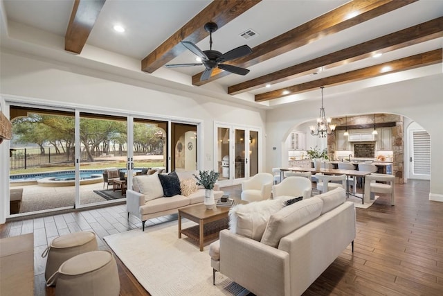 living room with beamed ceiling, ceiling fan with notable chandelier, and hardwood / wood-style flooring