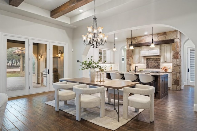 dining space featuring beamed ceiling, a notable chandelier, and dark wood-type flooring