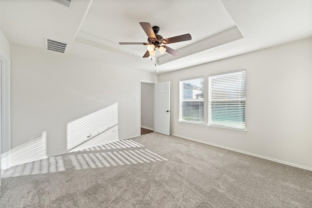 spare room featuring ceiling fan, a raised ceiling, and light carpet