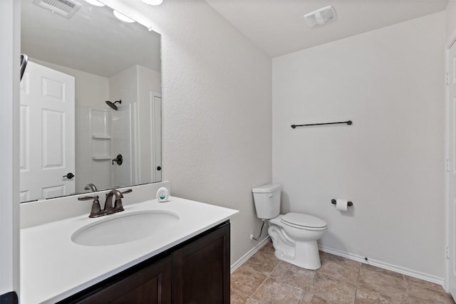 bathroom featuring toilet, vanity, and walk in shower