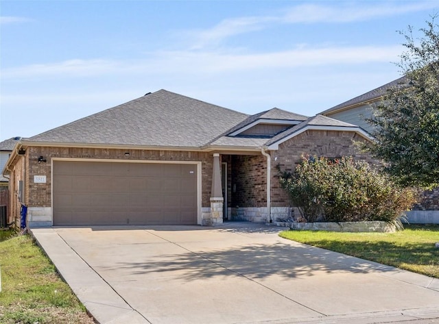 view of front of house with central AC unit, a garage, and a front yard