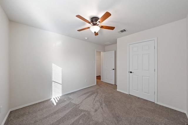 unfurnished bedroom with ceiling fan and light colored carpet