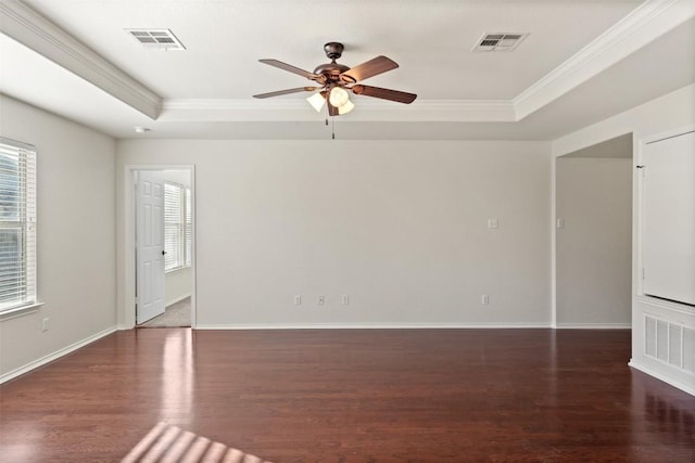 unfurnished room with a raised ceiling, ceiling fan, dark hardwood / wood-style flooring, and ornamental molding