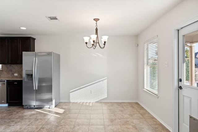 kitchen featuring backsplash, hanging light fixtures, a notable chandelier, dark brown cabinetry, and stainless steel appliances