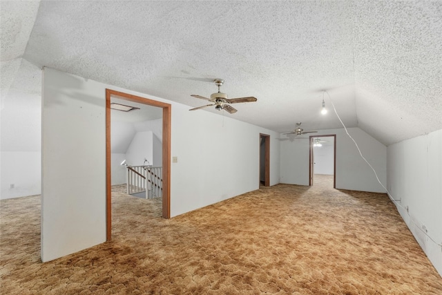 bonus room with lofted ceiling, a textured ceiling, and carpet flooring