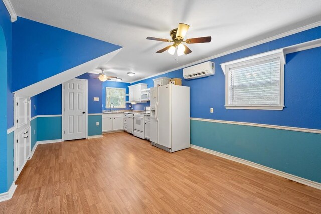 20024 W Lakeshore Dr, Magnolia, TX 77355 - kitchen with white appliances, a wall mounted AC, a ceiling fan, light wood-style floors, and white cabinetry