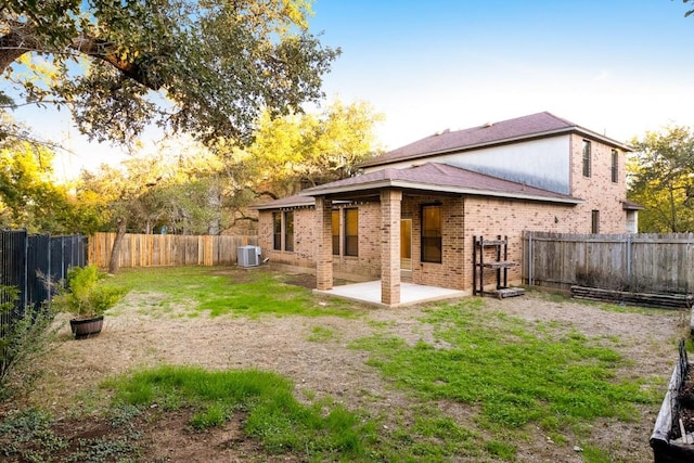 rear view of house with a yard, a patio, and central AC unit