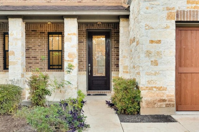 11125 Bastogne Loop, Austin, TX 78739 - property entrance featuring stone siding, covered porch, and brick siding