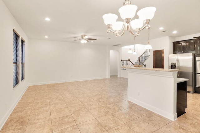 kitchen with stainless steel fridge with ice dispenser, ceiling fan with notable chandelier, light tile patterned floors, and pendant lighting