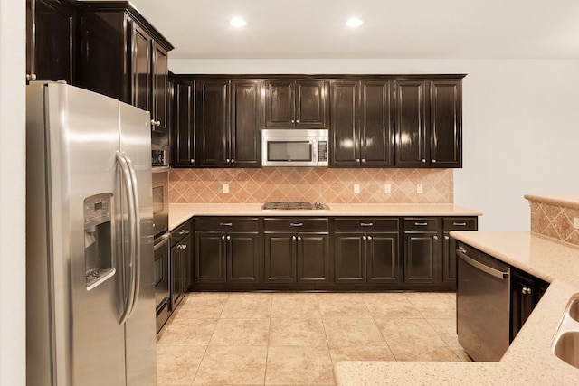 kitchen with appliances with stainless steel finishes, dark brown cabinetry, and tasteful backsplash