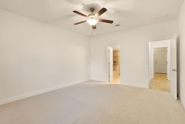 unfurnished bedroom with ceiling fan, ensuite bathroom, and light carpet