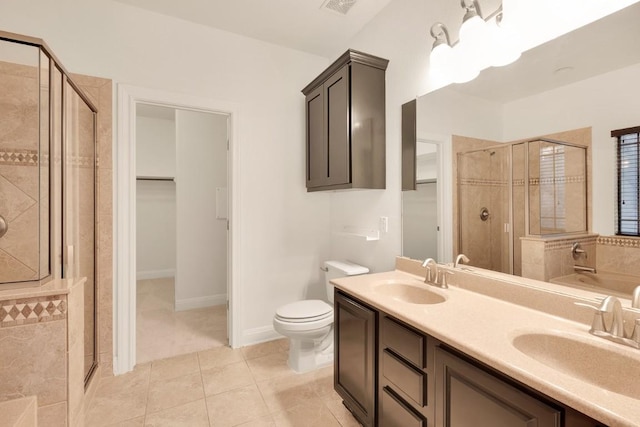 bathroom featuring tile patterned floors, toilet, vanity, and walk in shower