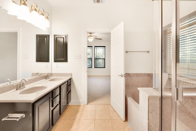 bathroom featuring tile patterned flooring, plenty of natural light, a relaxing tiled tub, and ceiling fan