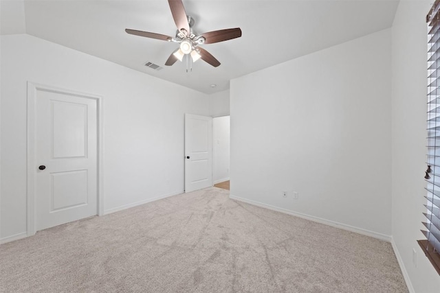 spare room featuring light colored carpet, vaulted ceiling, and a healthy amount of sunlight