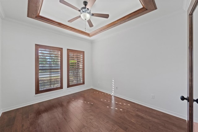 empty room featuring ceiling fan, dark hardwood / wood-style flooring, crown molding, and a tray ceiling