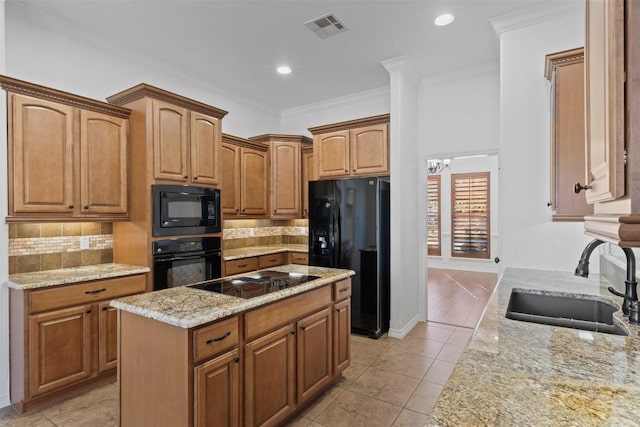 kitchen with sink, light stone counters, backsplash, crown molding, and black appliances