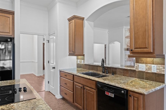 kitchen featuring black appliances, crown molding, sink, light stone countertops, and light tile patterned floors