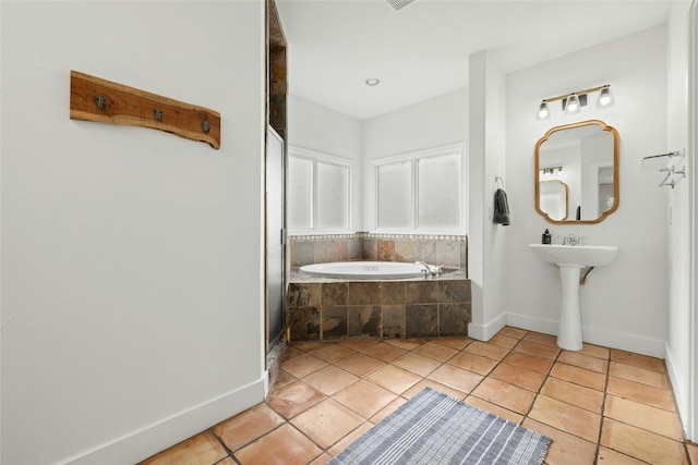 bathroom featuring a relaxing tiled tub and tile patterned floors