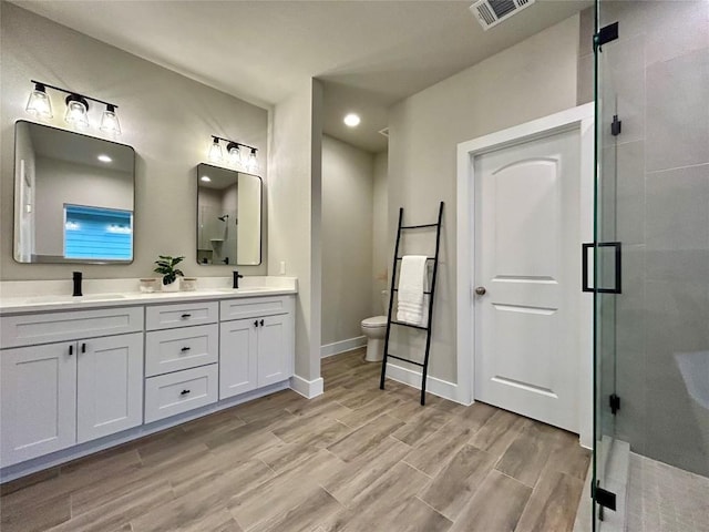 bathroom with walk in shower, toilet, vanity, and hardwood / wood-style flooring