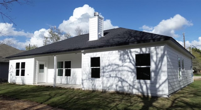 back of house with a lawn and covered porch