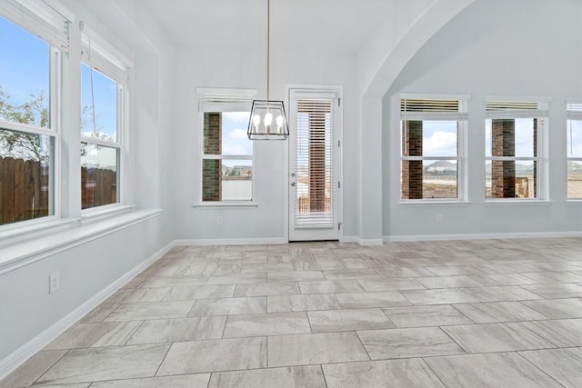 unfurnished sunroom featuring an inviting chandelier