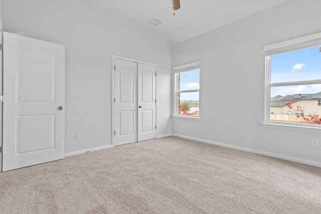 unfurnished bedroom with ceiling fan, light colored carpet, and a closet