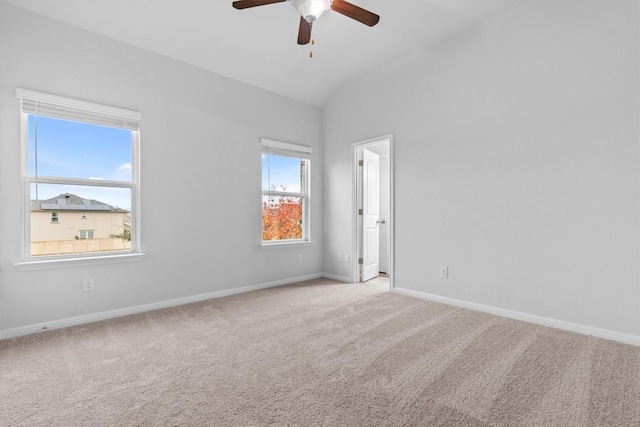 carpeted empty room featuring ceiling fan and vaulted ceiling