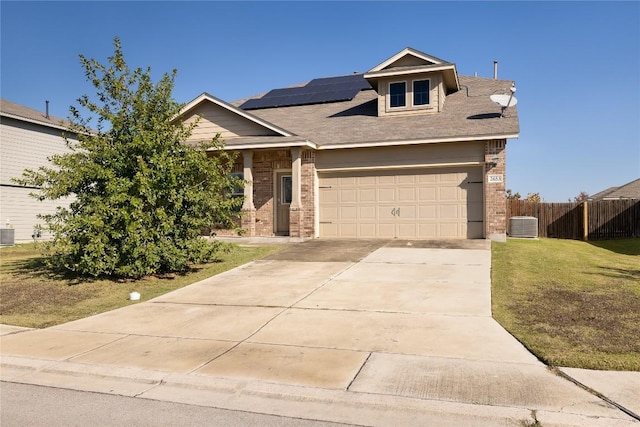 view of front facade featuring a front yard, solar panels, and a garage