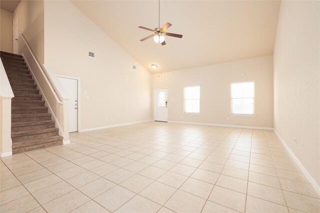 unfurnished living room with ceiling fan, high vaulted ceiling, and light tile patterned floors