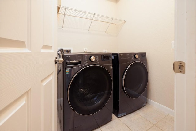 laundry area featuring washer and dryer and light tile patterned floors