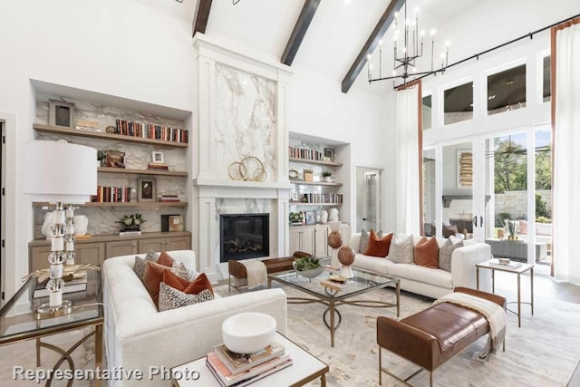 living room featuring beamed ceiling, a high end fireplace, a chandelier, and high vaulted ceiling