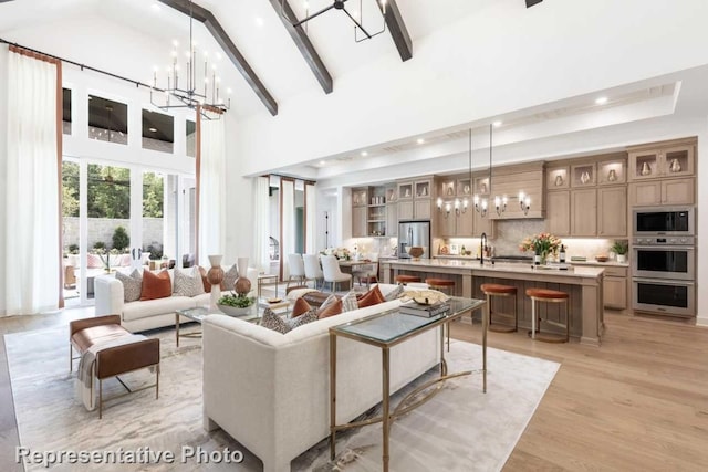 living room with beam ceiling, light hardwood / wood-style flooring, high vaulted ceiling, and a notable chandelier