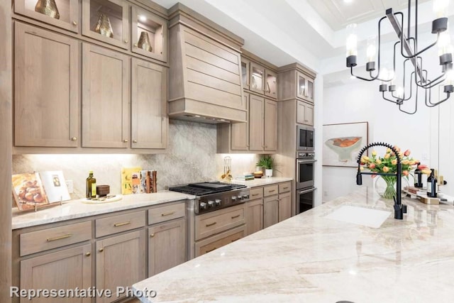 kitchen featuring light brown cabinets, premium range hood, sink, light stone counters, and stainless steel appliances