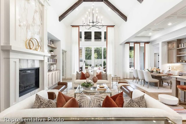 living room with beamed ceiling, a fireplace, high vaulted ceiling, and an inviting chandelier