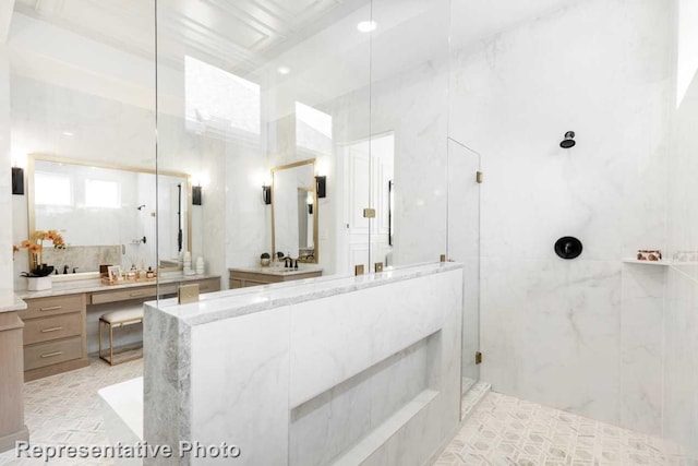 bathroom with a tile shower and vanity