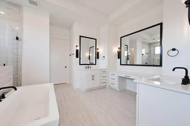 790 Old Stone Rd, Austin, TX 78737 - bathroom featuring a stall shower, two vanities, a soaking tub, wood finished floors, and baseboards