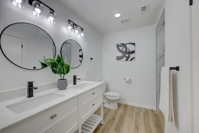 bathroom featuring vanity, hardwood / wood-style flooring, and toilet