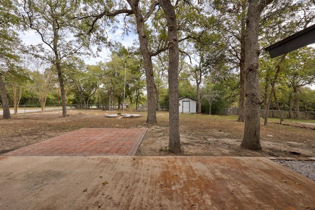 view of yard featuring a shed and a patio area