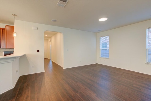 empty room with plenty of natural light and dark hardwood / wood-style floors