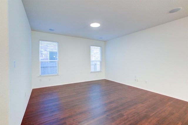 spare room with dark hardwood / wood-style floors and a healthy amount of sunlight