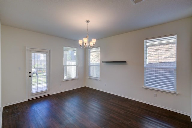 interior space with a wealth of natural light, dark hardwood / wood-style floors, and a notable chandelier