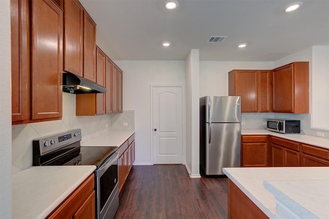 kitchen with dark hardwood / wood-style floors, backsplash, and appliances with stainless steel finishes