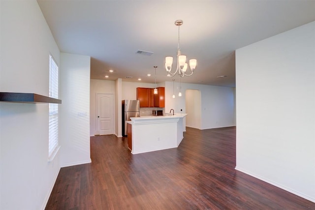 kitchen featuring stainless steel refrigerator, decorative light fixtures, dark hardwood / wood-style floors, and an inviting chandelier